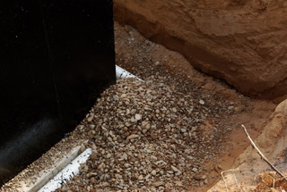 A picture of rock over a foundation drain pipe