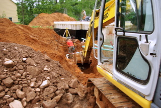 A picture of a excavator digging a water line