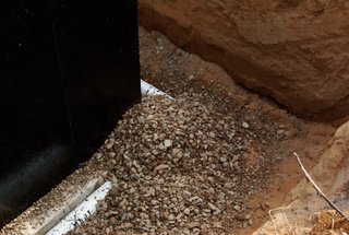 A picture of rock over a foundation drain pipe